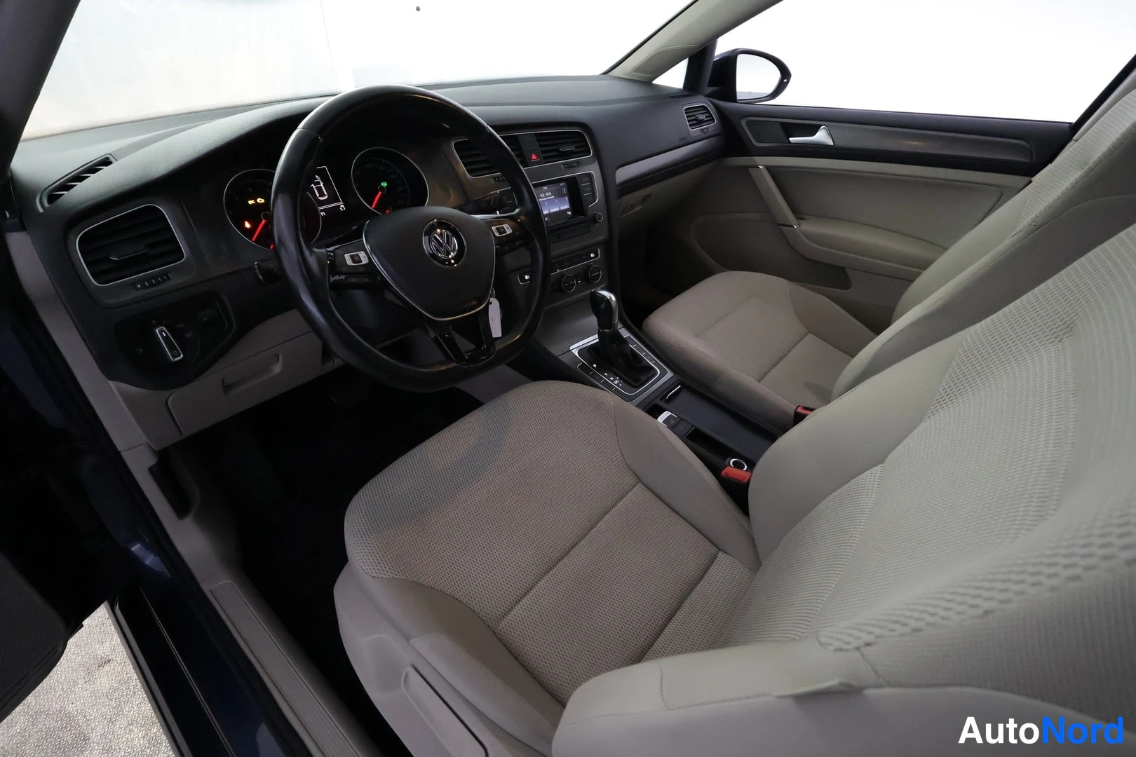 Ohjaamo: Interior view showing two front seats with dark grey dashboard and multifunction steering wheel visible