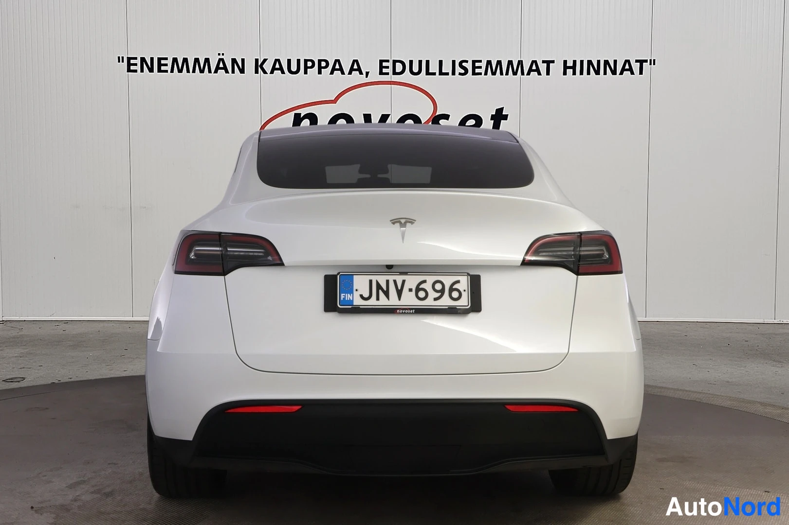 Takaa: Valkoinen Tesla Model Y suoraan takaa kuvattuna, rekisterikilpi.