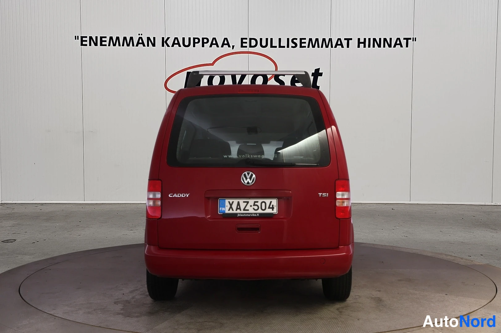 Takaa: Punainen Volkswagen Caddy suoraan takaa kuvattuna, CADDY- ja TSI-merkinnät sekä -kilpi näkyvissä.