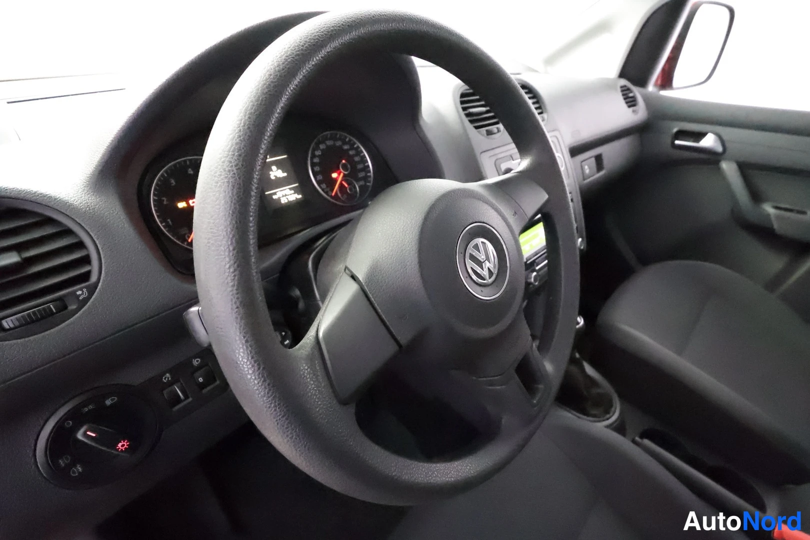 Etuviisto, nokka vasemmalle: Ohjaamo näyttää ohjauspyörän, mittaristön ja kojelaudan Volkswagenissa.