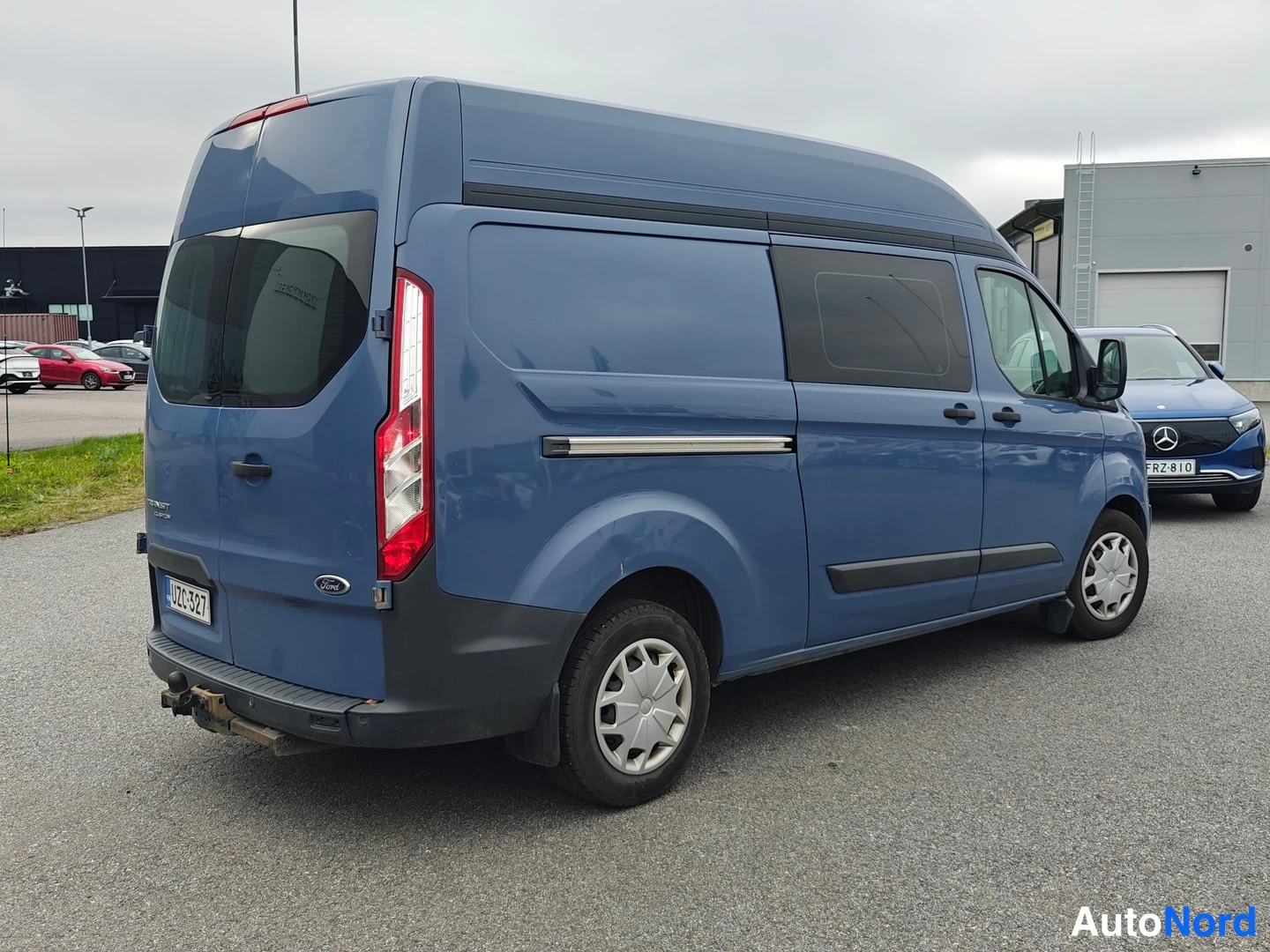 Takaviisto: Ford Transit Custom -pakettiauto takaa oikealta kolmasosan kuvakulmassa, korkeakattoinen sininen korimalli.