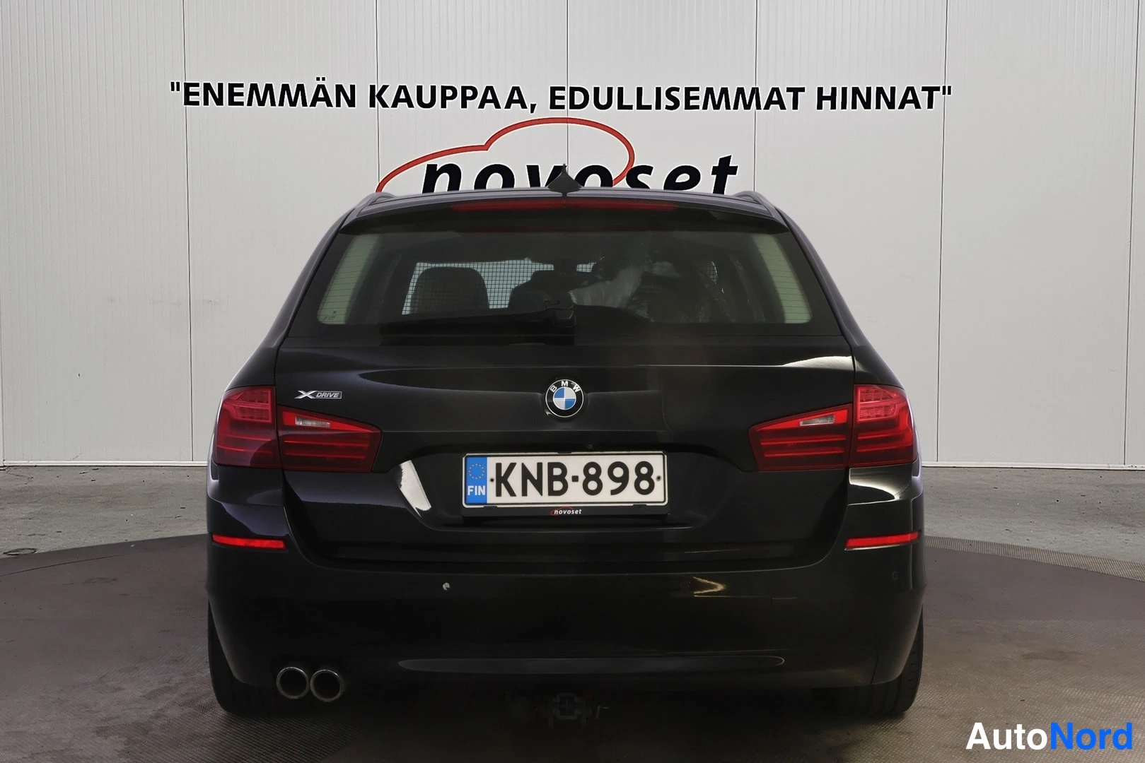 Takaa: Musta BMW:n takapansi suoraan takaa, rekisteritunnus, kaksoispakoputki.