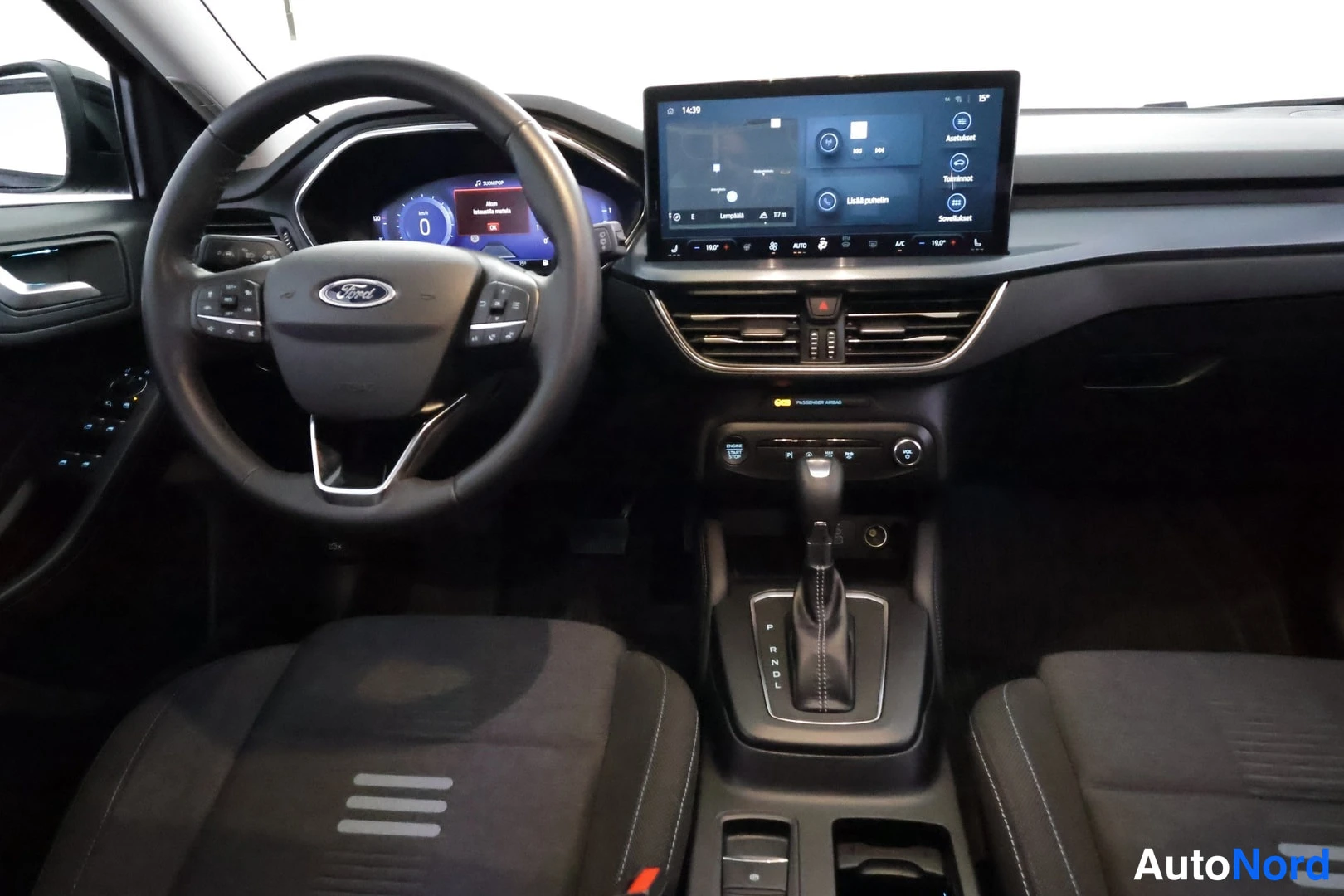 Yksityiskohta: Ohjaamo näkyy edestä: Ford-merkkinen ohjauspyörä, digitaalinen mittaristo ja keskikonsolin suuri kosketusnäyttö.