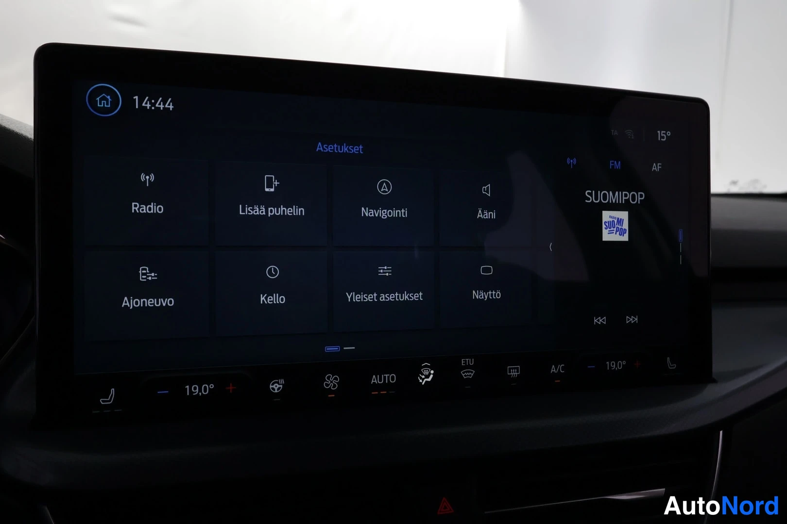 Muu: Infotainment-näytön Asetukset-valikko, jossa Radio, Lisää puhelin, Navigointi, Ääni, Ajoneuvo, Kello, Yleiset asetukset ja Näyttö.