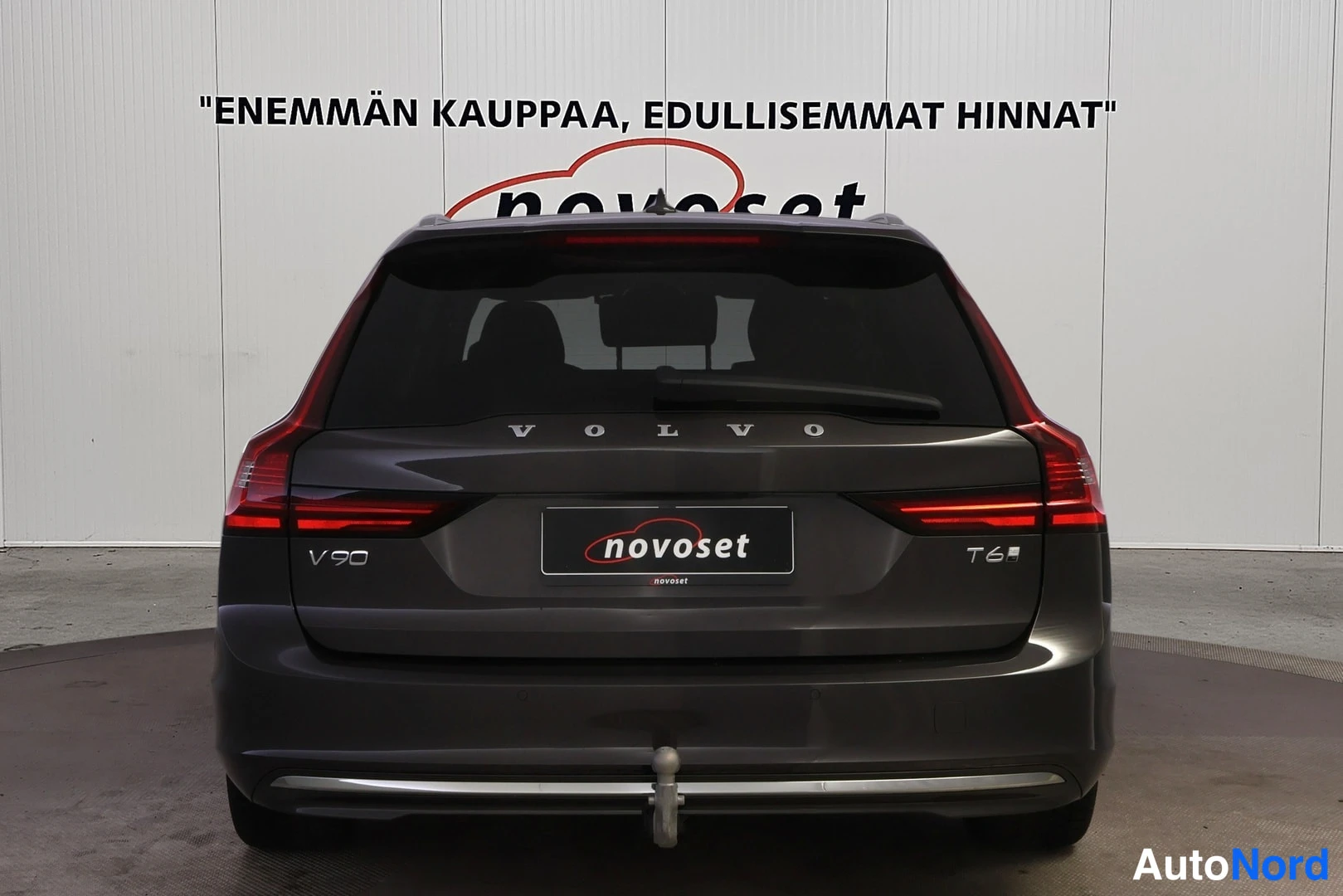 Takaa: Tummanharmaa Volvo V90 -farmari suoraan takaa, perävalot ja takaluukun V90-merkintä näkyvissä.