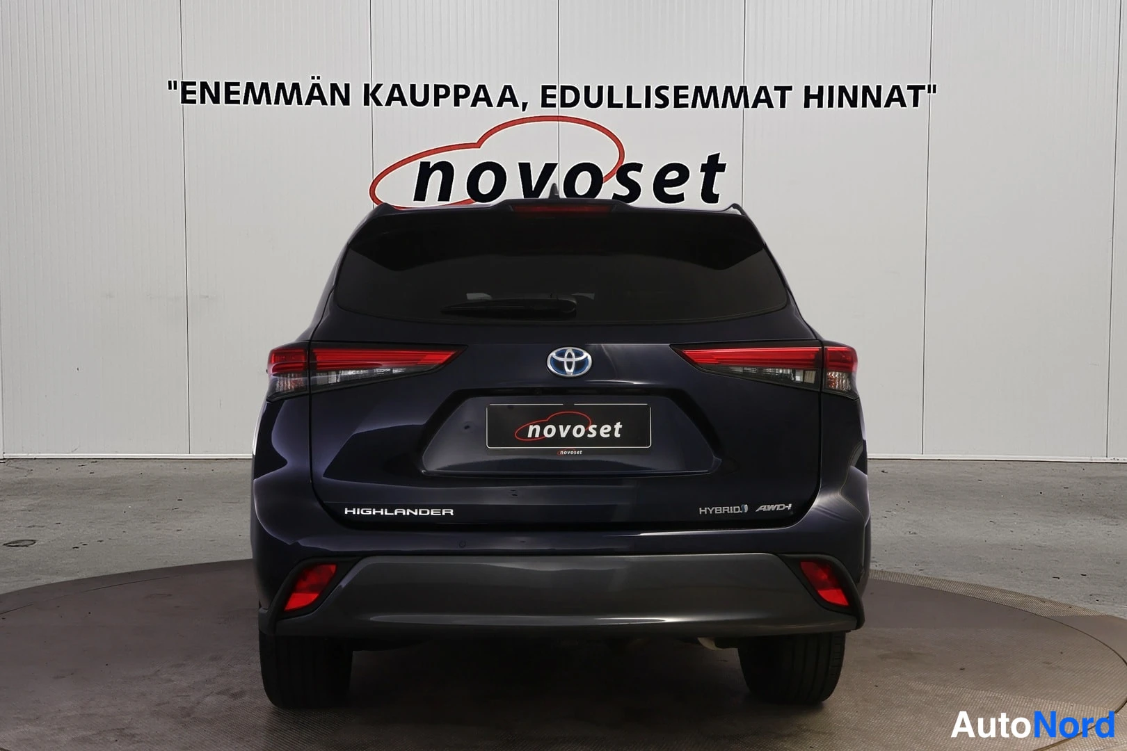 Takaa: Toyota Highlanderin suora takaosakuva, HIGHLANDER- ja HYBRID AWD-i -tekstit takaluukussa sekä Toyota-merkki keskellä.