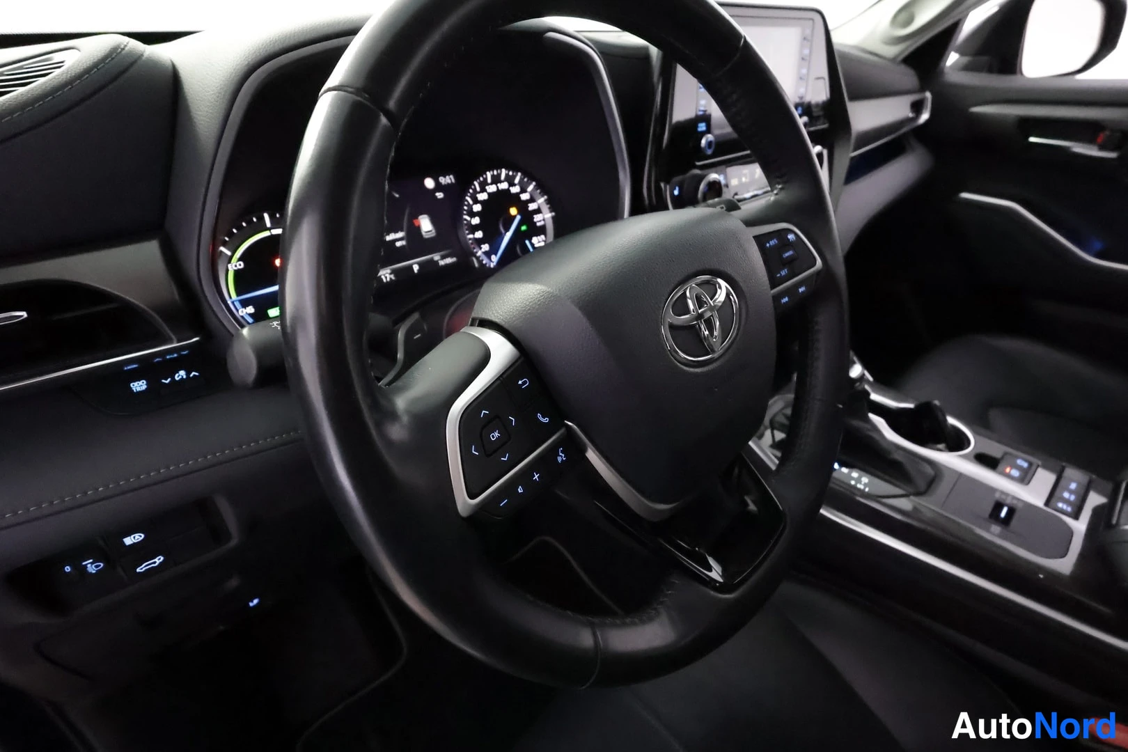 Muu: Kuljettajan paikan kojelauta ja Toyota-merkillinen ohjauspyörä; mittaristossa hybridinäytöt, keskellä infotainment-näyttö ja vaihteenvalitsin.