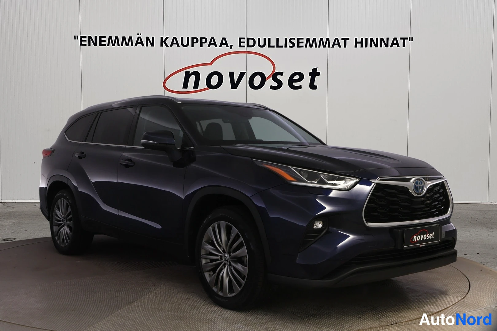 Etuviisto, nokka oikealle: Sinimusta Toyota Highlander -maasturin etukulma etuosa ja sivu näkyvissä kuvassa oikealla.