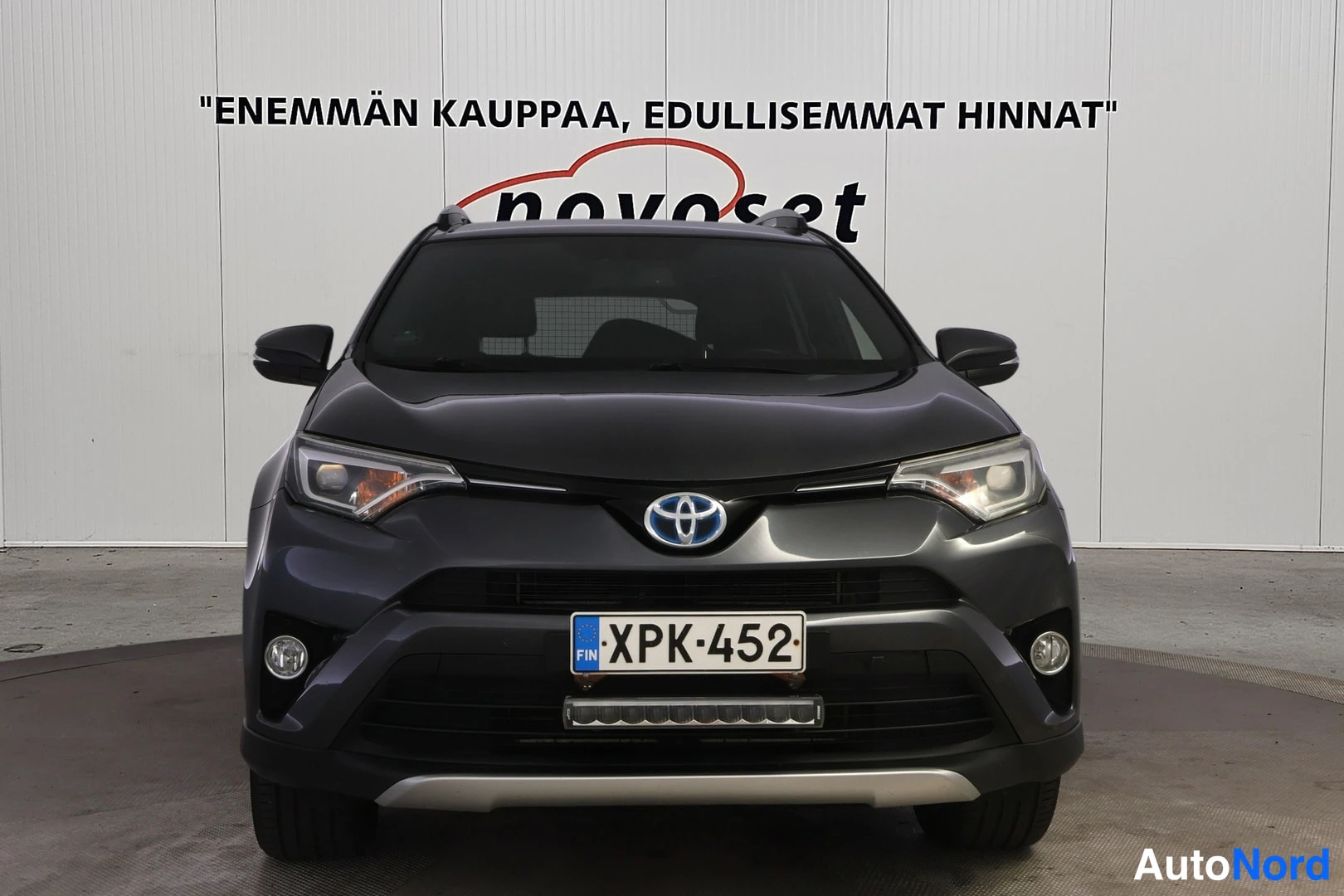 Edestä: Toyota RAV4 suoraan edestä; Toyota-merkki, etuvalot ja rekisterikilpi näkyvissä.