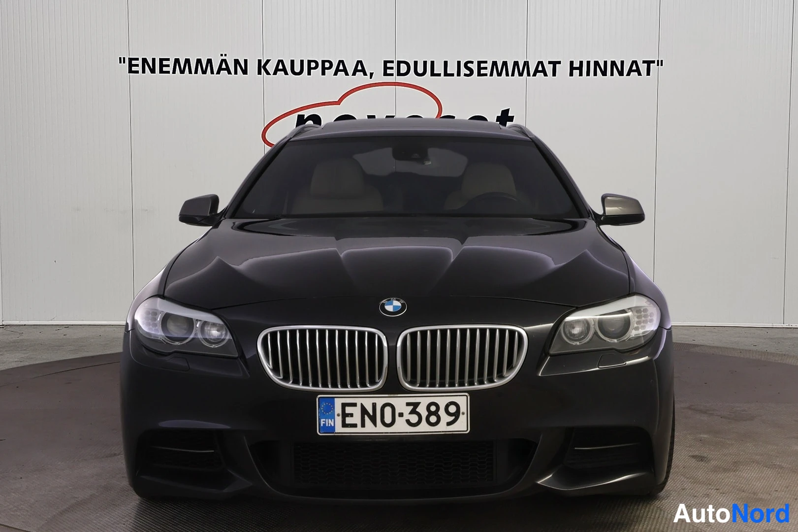 Edestä: Auton keula suoraan edestä: BMW-merkki konepellillä, pystysäleinen etugrilli, ajovalot ja rekisterikilpi.