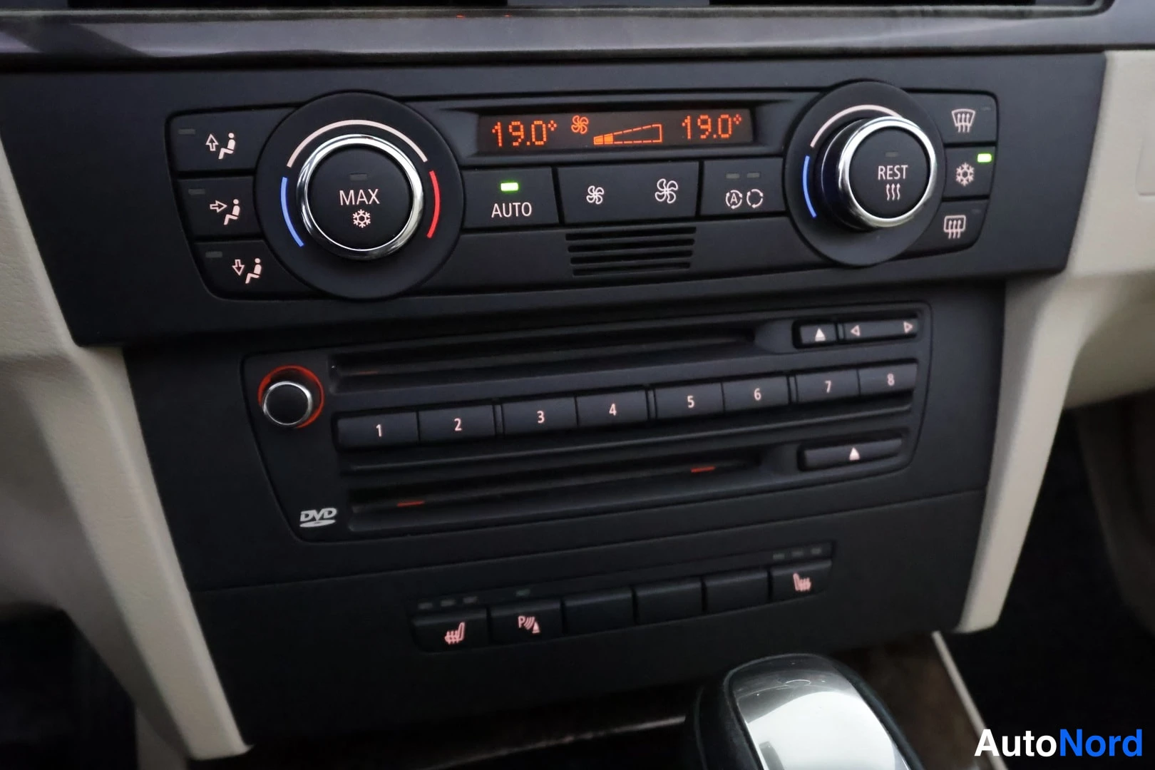 Muu: Autojen keskikonsolin ilmastointipaneeli, jossa näkyy 19,0 °C ja DVD-soitin.