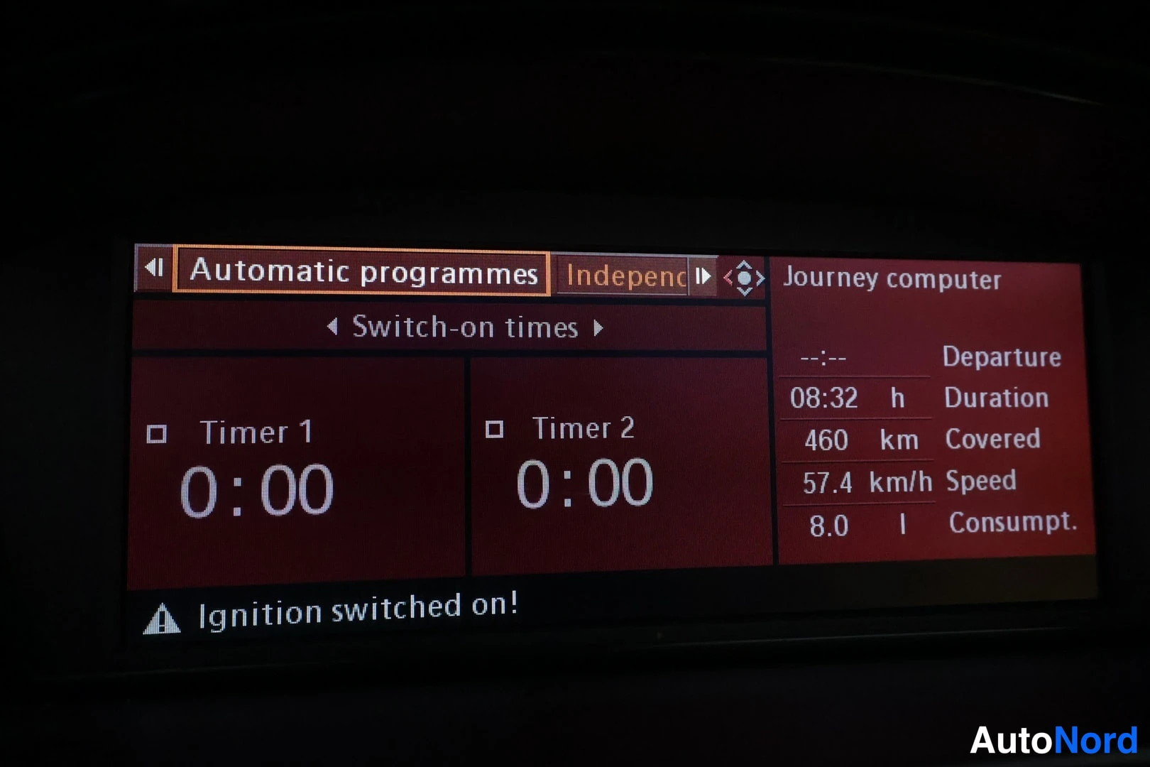 Muu: Auton kojelaudan näyttö punaisessa tilassa: Automatic programmes -valikko, jossa Timer 1 ja Timer 2 molemmat 0:00, ja Journey computer -tiedot.