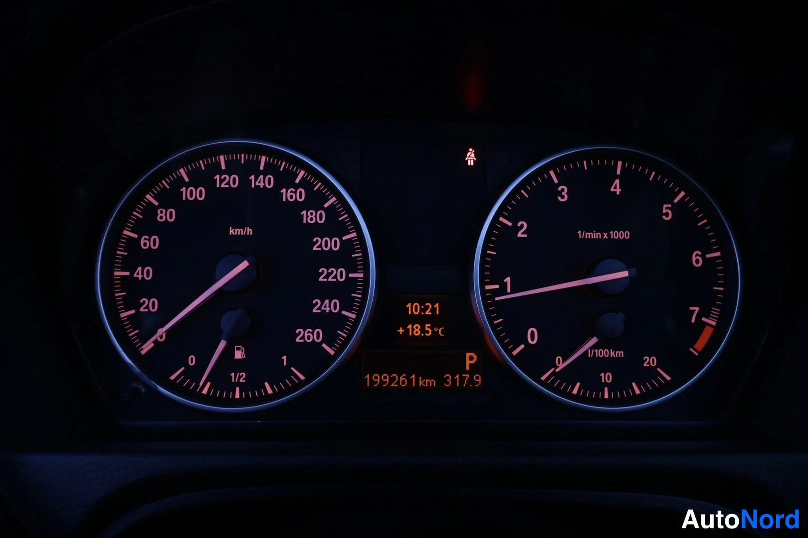 Muu: Auton mittaristo pimeässä: nopeusmittari ja kierroslukumittari, näytössä kellonaika 10:21, lämpötila +18,5 °C, odometerilukema 199261 km ja vaihdepjas P.