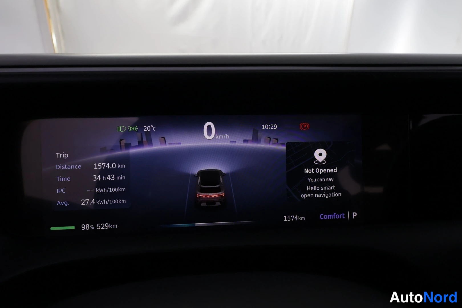 Muu: Auton digitaalinen mittarinäyttö: nopeus 0 km/h, matkurin matka 1574,0 km, keskulitkuluku 27,4 kWh/100 km, lataus 98 %, toimintamatka 529 km, ajotila Comfort ja