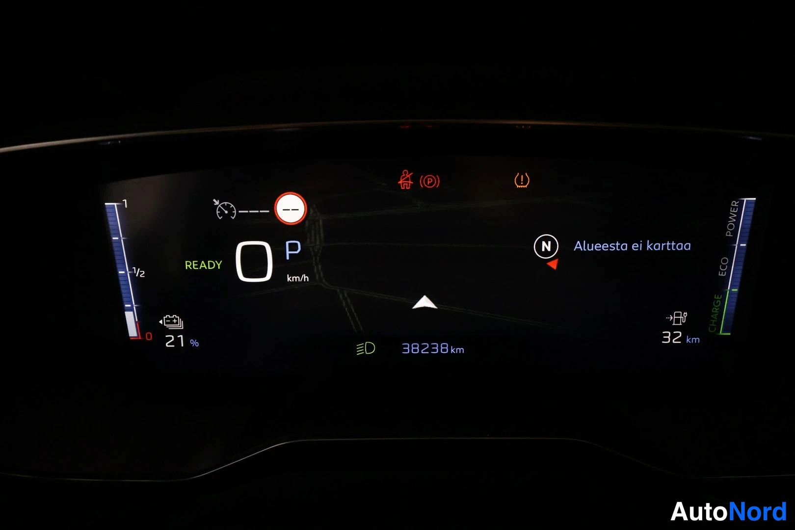 Muu: Kojetaulun digitaalinen näyttö pimeässä: READY-teksti, P-vaihde, nopeus 0 km/h, kirjanmitto 38238 km, akun varaus 21 % ja toimintamatka 32 km, teksti 'Alueesta