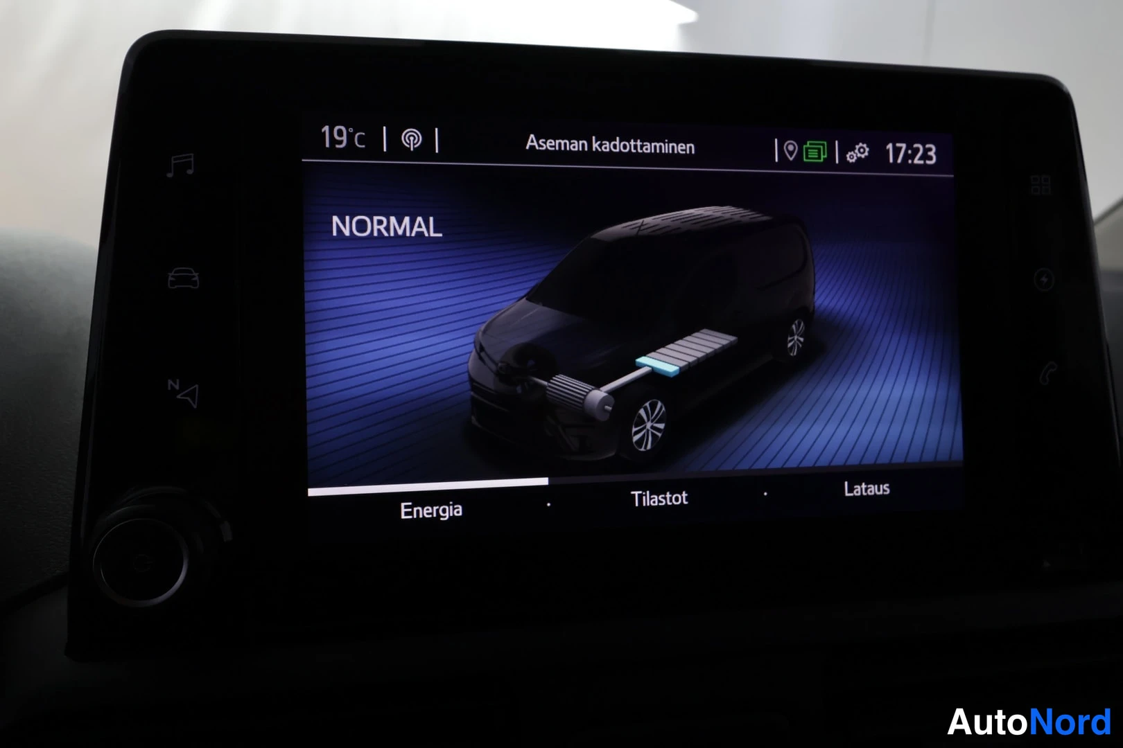 Muu: Auton infotainment-näytön Energia-sivu NORMAL-tilassa, jossa esitetään ajoneuvon energiankulku; alapalkissa Energia, Tilastot ja Lataus.