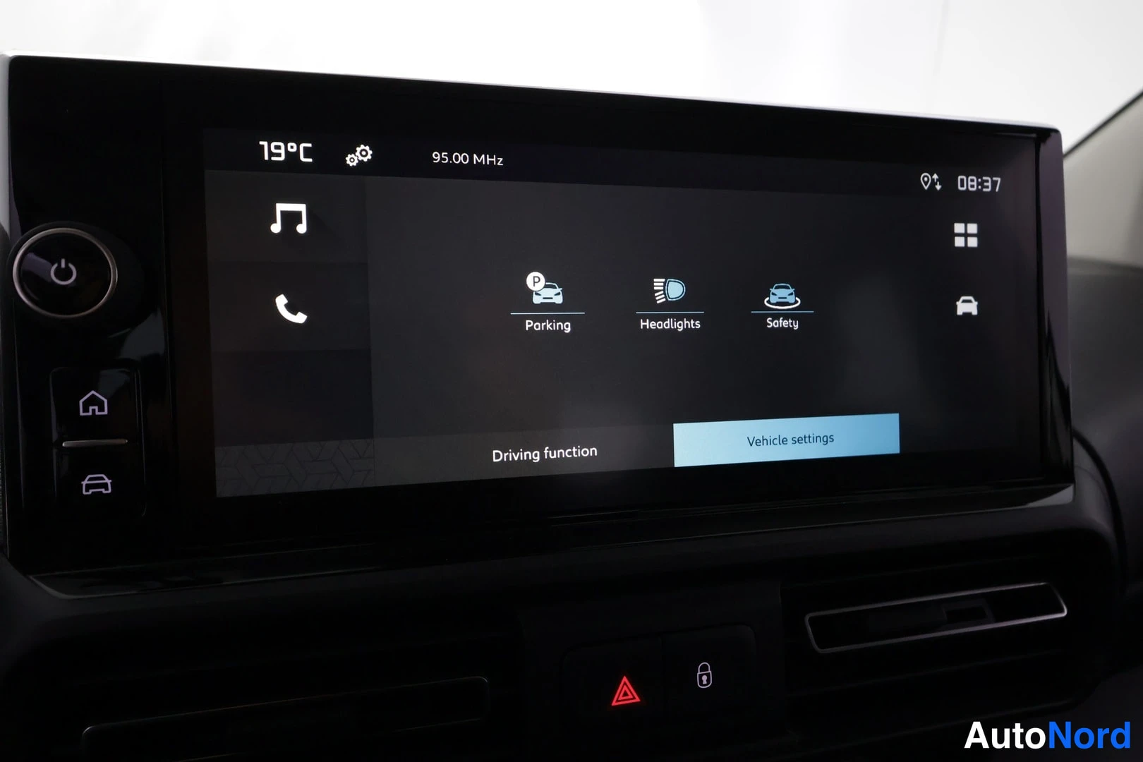 Muu: Kojeiston infotainment-näyttö Vehicle settings -valikossa, jossa kohdat Parking, Headlights ja Safety; alareunassa Driving function ja valittu Vehicle settings.