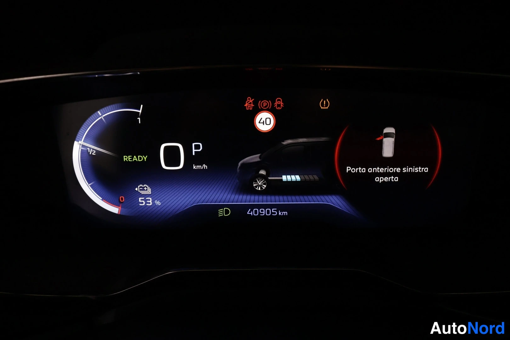 Muu: Digitaalinen mittaristo pimeässä: READY-merkintä, nopeus 0 km/h, vaihde P, akun varaus 53 %, matkamittari 40905 km ja viesti 'Porta anteriore sinistra aperta'.