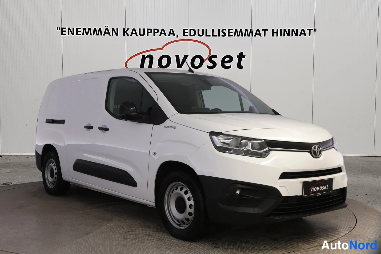 Etuviisto, nokka oikealle: Valkoisen Toyota Proace City -pakettiauton etukulmanäkymä, kohta oikealla, tumma etusäleikkö ja novoset-tunnus etupuskurissa, valkoinen tausta.