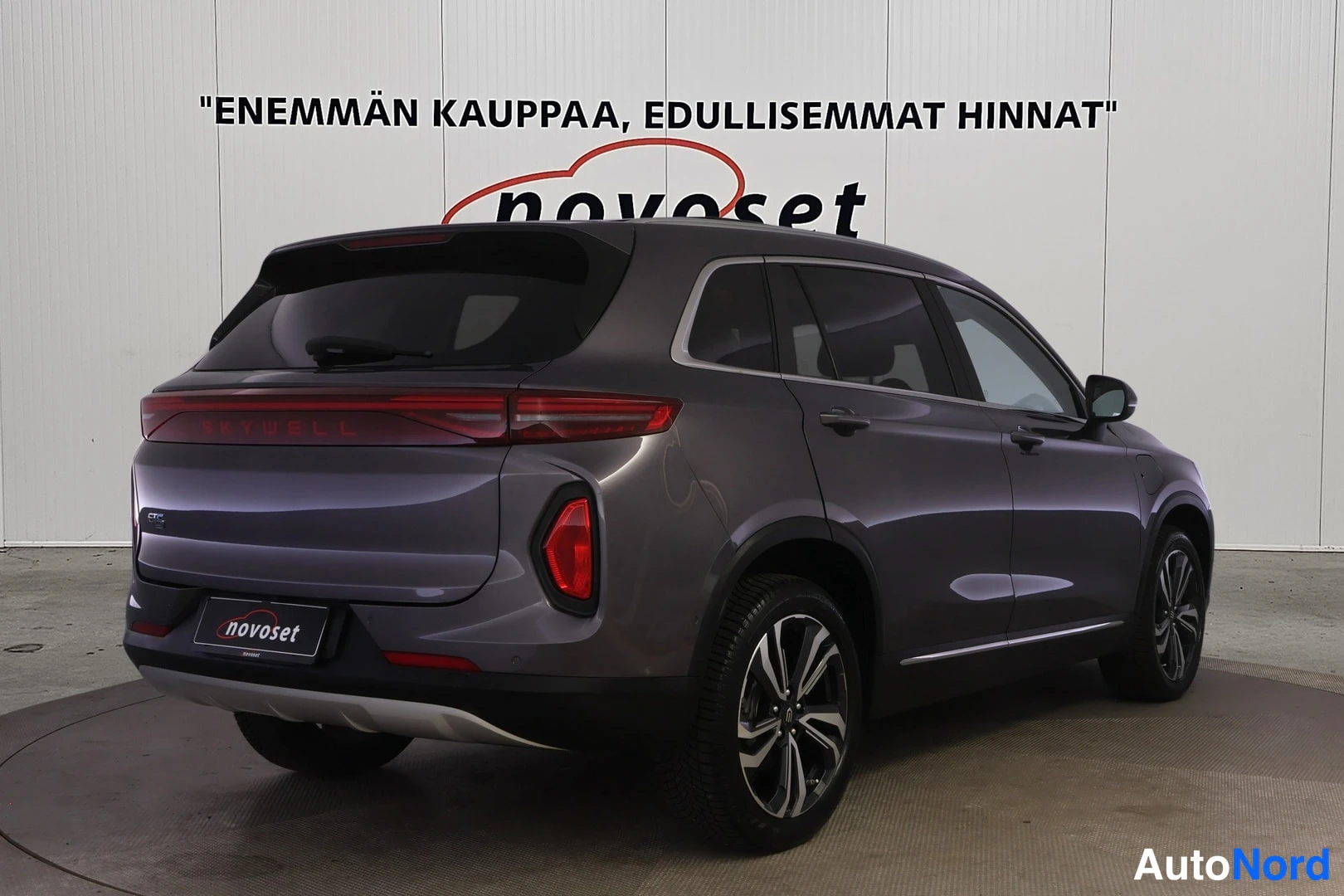 Takaviisto: Auto takaa oikealta sivulta, perä ja oikea kylki näkyvissä, tummanharmaa SUV.