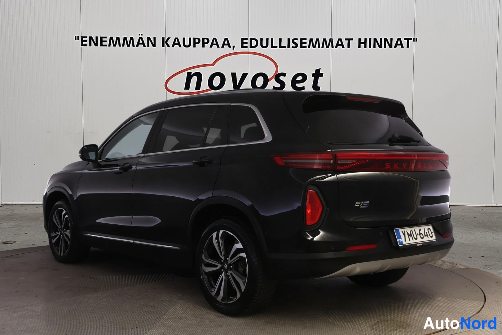 Takaviisto: Musta SUV takakulmakuvassa perä oikealla, punaiset takavalot ja rekisterikilpi.