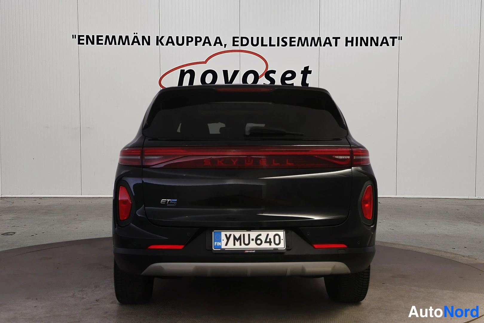 Takaa: Musta SUV suoraan takaa kuvattuna; takaluukussa SKYWELL-teksti, rekisterikilpi.