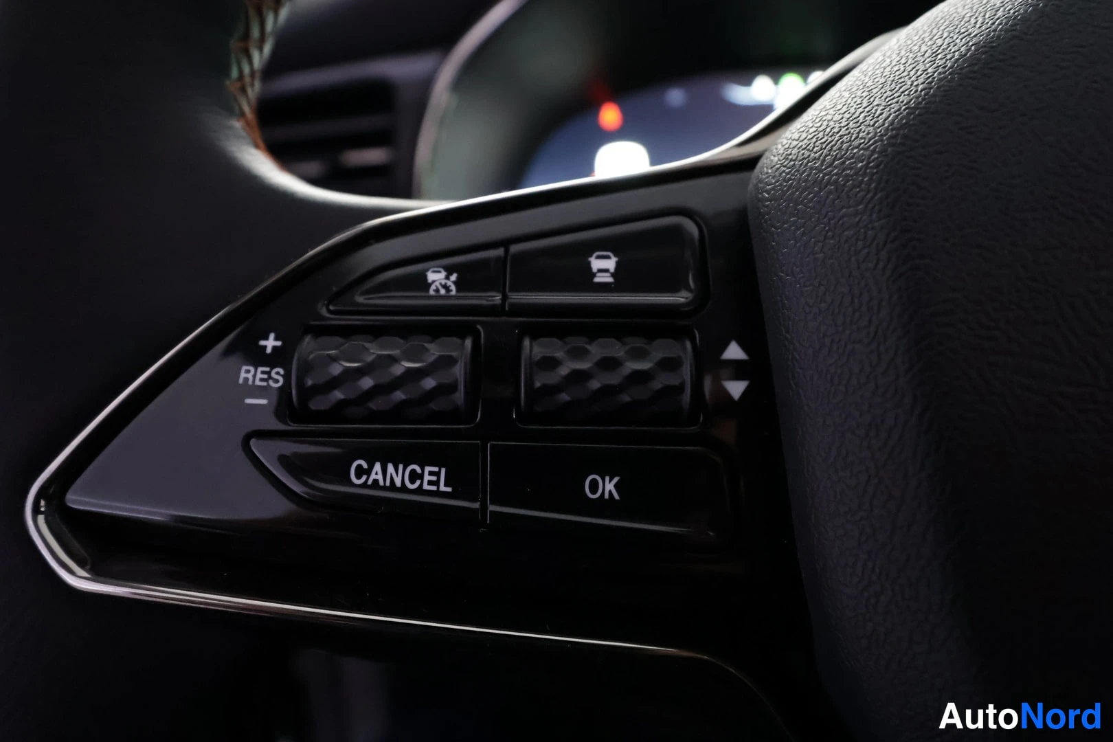 Yksityiskohta: Ohjauspyörän oikean puolen säätöpainikkeet: cruise control -toiminnot (RES/+, CANCEL, OK) ja rullaavat säädinnupit.