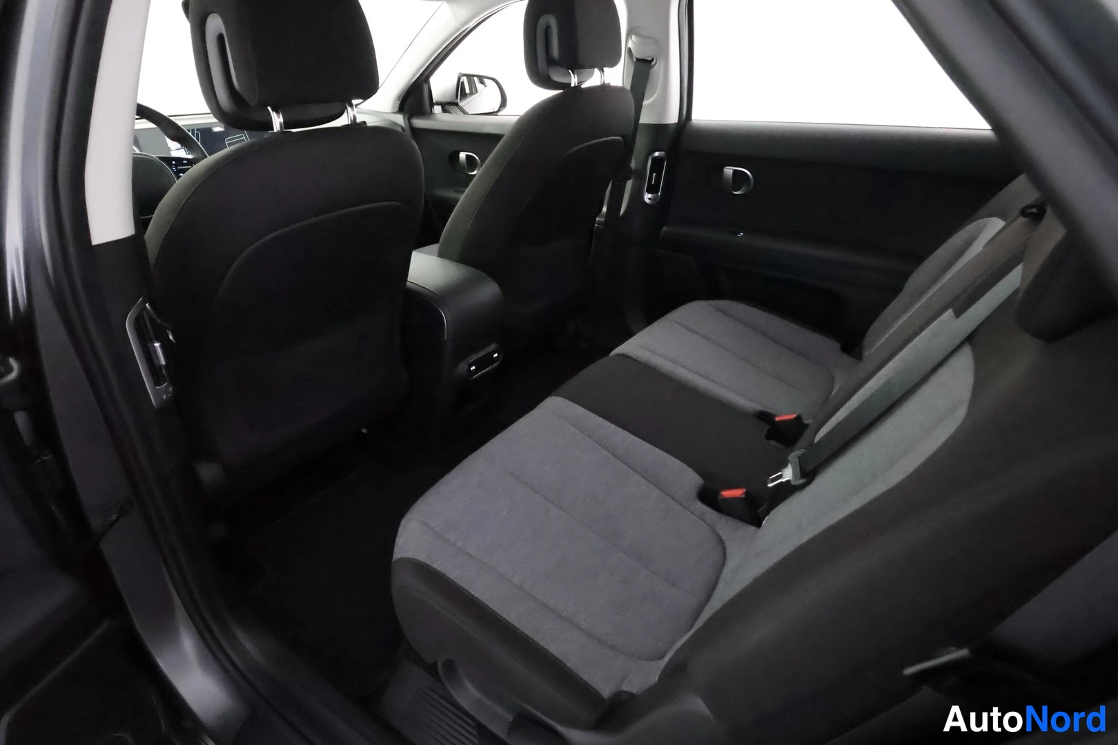 Takaistuimet: Rear seating area showing three passenger seats in two-tone fabric.