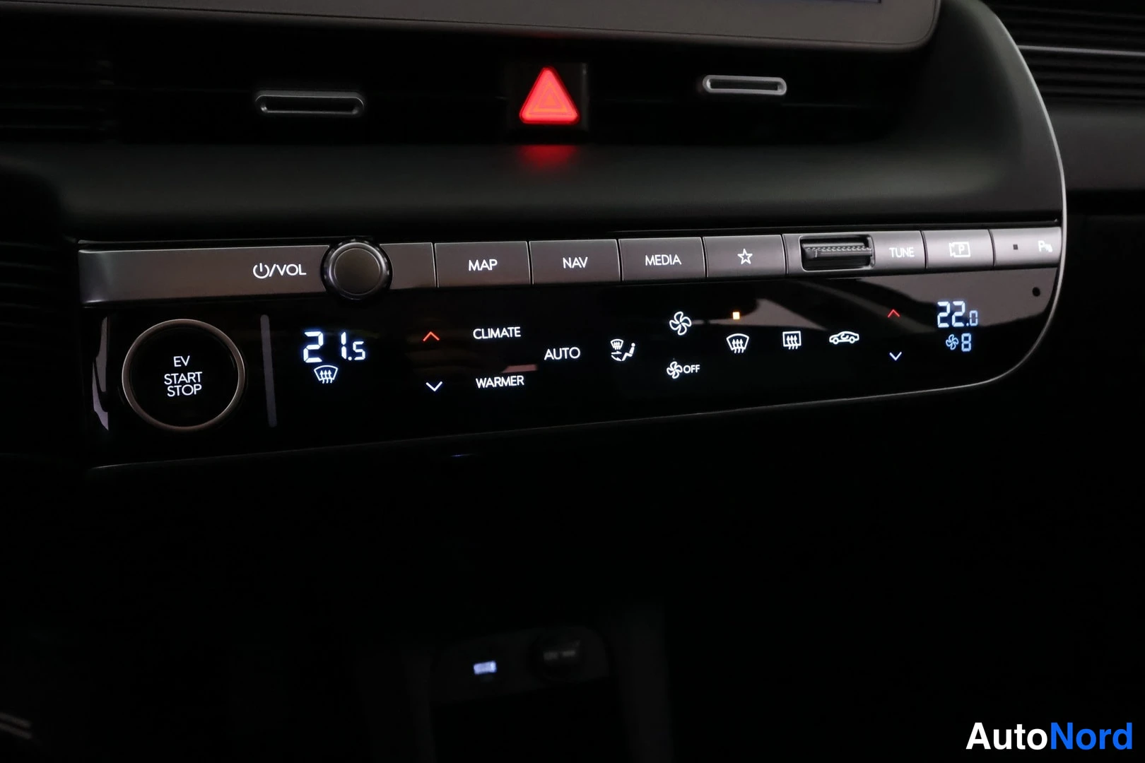 Yksityiskohta: Keskikonsolin paneeli: EV START STOP -painike, automaattinen ilmastointi (AUTO, CLIMATE, WARMER), MAP/NAV/MEDIA-painikkeet ja lämpötilat 21,5 ja 22,0 astetta.