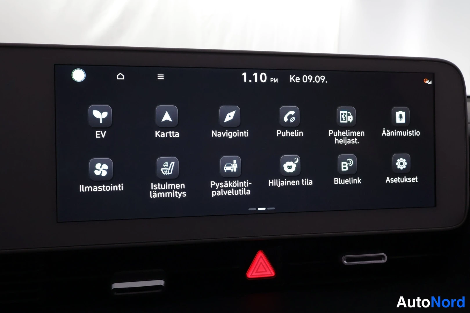 Yksityiskohta: Infotainment-näytön päävalikko valikoinneilla EV, Kartta, Navigointi, Puhelin, Ilmastointi, Asetukset.