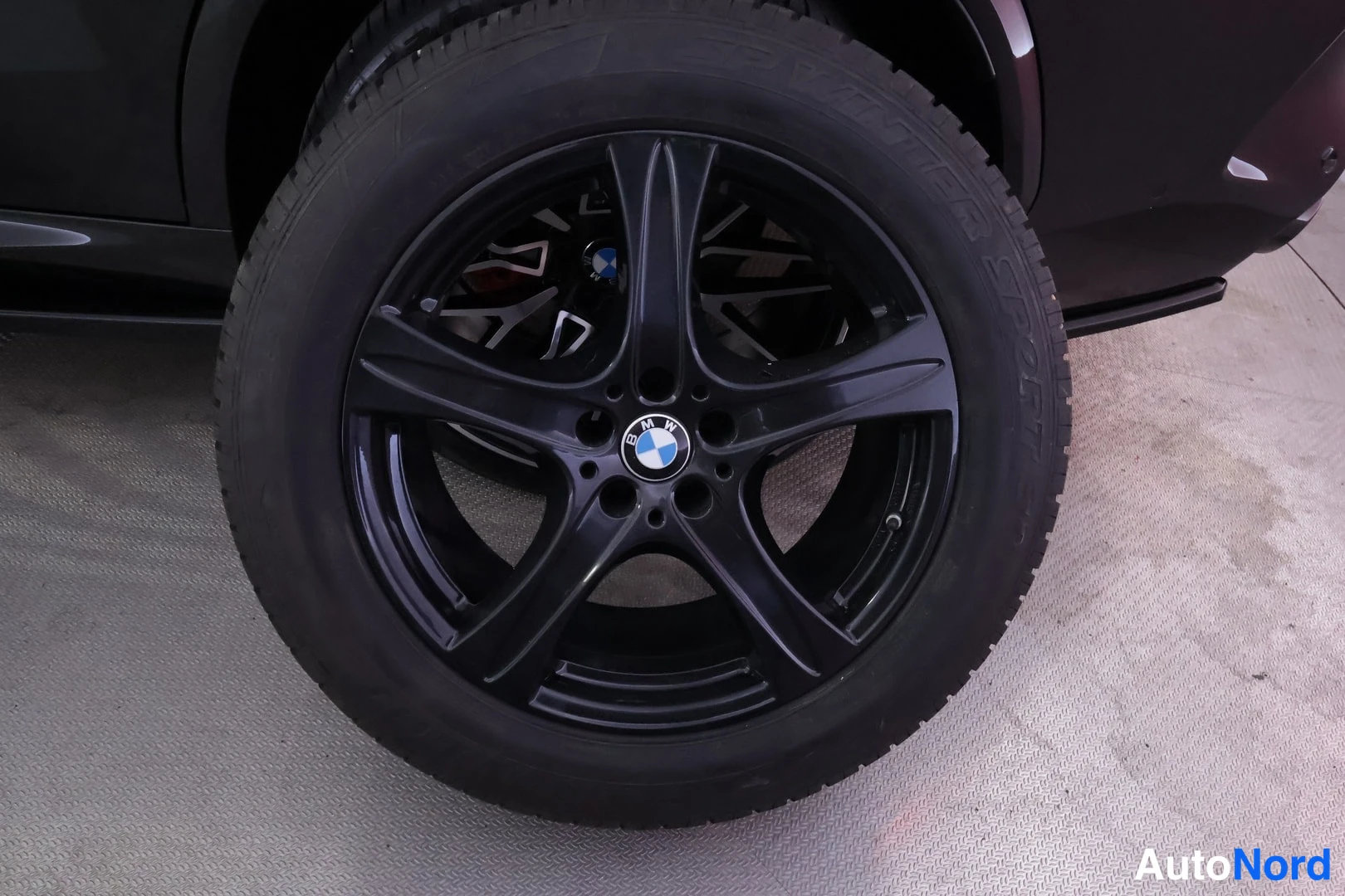 Yksityiskohta: Musta BMW-vanne ja rengas lähikuvassa