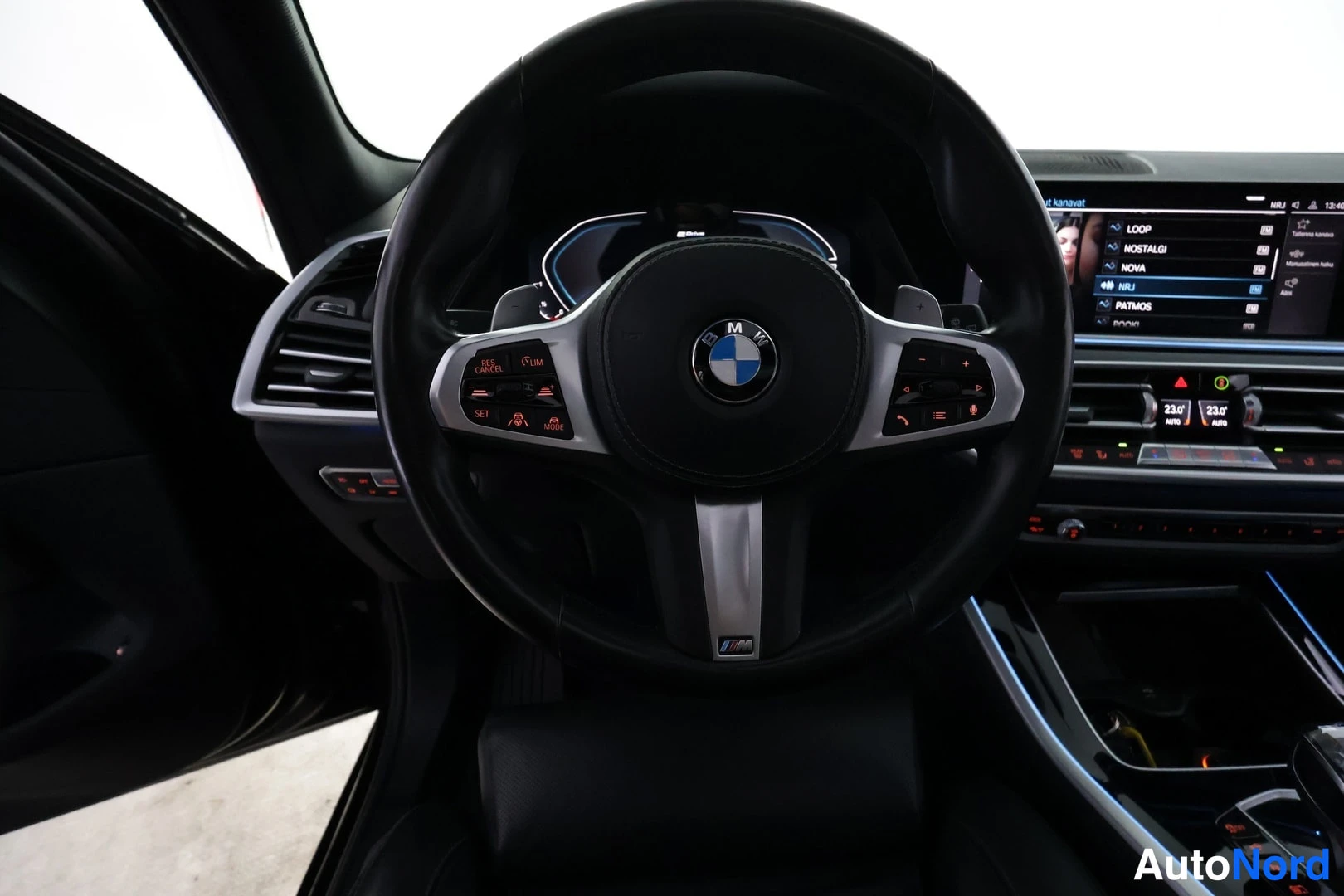 Muu: BMW M-ohjauspyörä suoraan edestä, kojelaudan näytöt ja ilmastointi taustalla