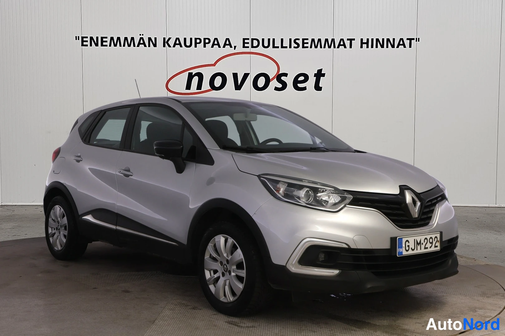 Etuviisto, nokka oikealle: Etupää ja vasen sivu: hopeanharmaa Renault Captur, jonka etuosa (grilli ja valot) ja vasen kylki ovat näkyvissä. Kevyenmetallivanteet.