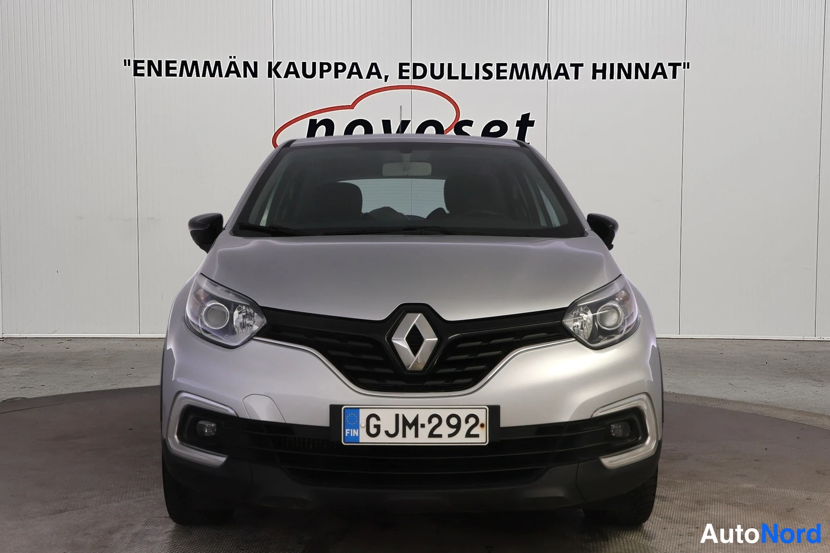 Edestä: Suora etukuva: hopeanharmaa Renault, jossa on grille, Renault-logolla, sekä etulampit ja rekisterikilpi.