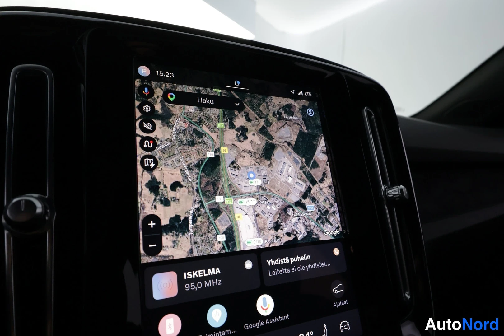 Muu: Keskikonsolin pystysuora infotainment-näyttö, jossa Google Maps kartta ja ali-sovellukset kuten ISKELMA-radio.