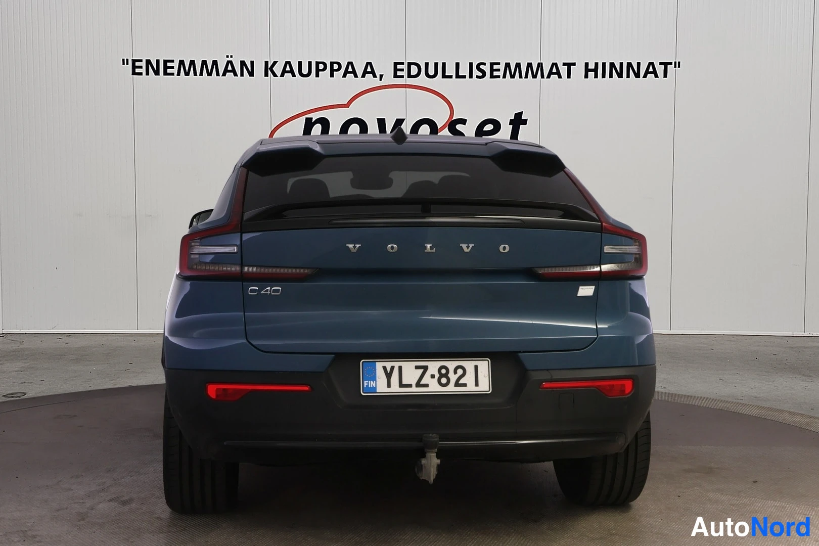 Takaa: auton takaosa suoraan takaa: VOLVO-kyltti ja C40-merkintä takaluukussa, rekisterikilpi, veto koukku kiinnitettynä