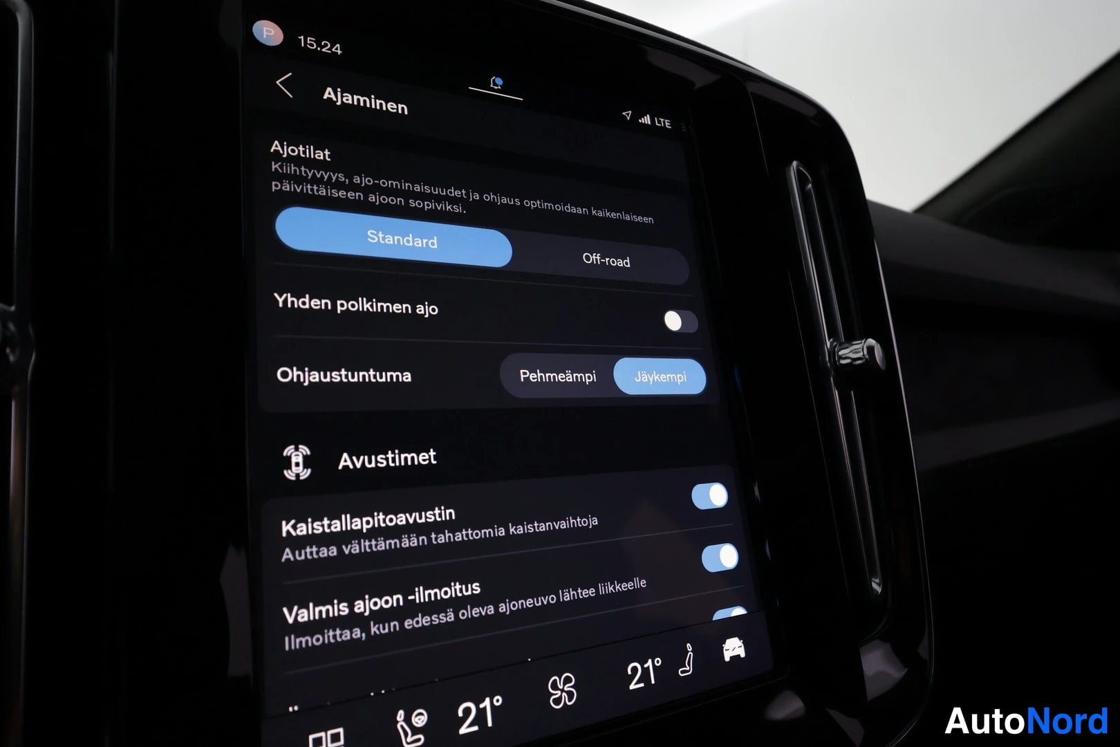 Ohjaamo: Täysin valkoista tekstiä sisältävä automaatti-ilmastointiohjain. Näytössä nähdään 'Standard', 'Off-road', 'Yhden polkimen ajo' ja 'Ohjaustuntuma Pehmeämpi'. Avu