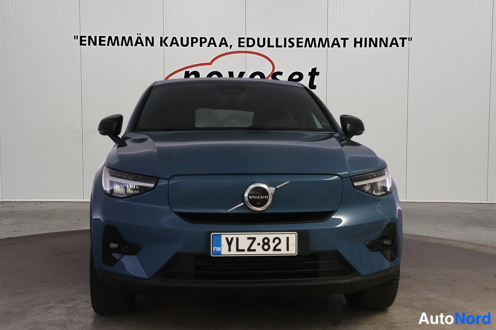 Edestä: Sinisen­harmaan auton etunäkymä, rekisteritunnus.