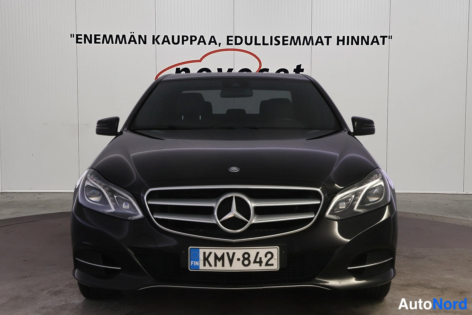 Edestä: Mustan Mercedes-Benzin suora etunäkymä, etusäleikkö ja rekisterikilpi.