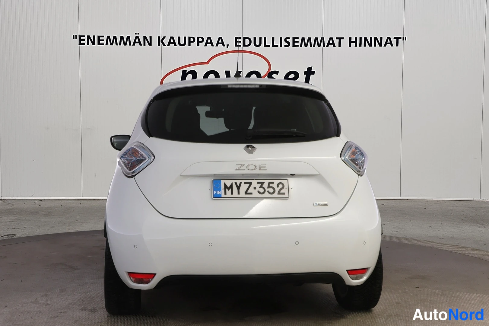 Takaa: Valkoinen Renault Zoe suoraan takaa kuvattuna, perällä ZOE-merkintä ja rekisteritunnus.