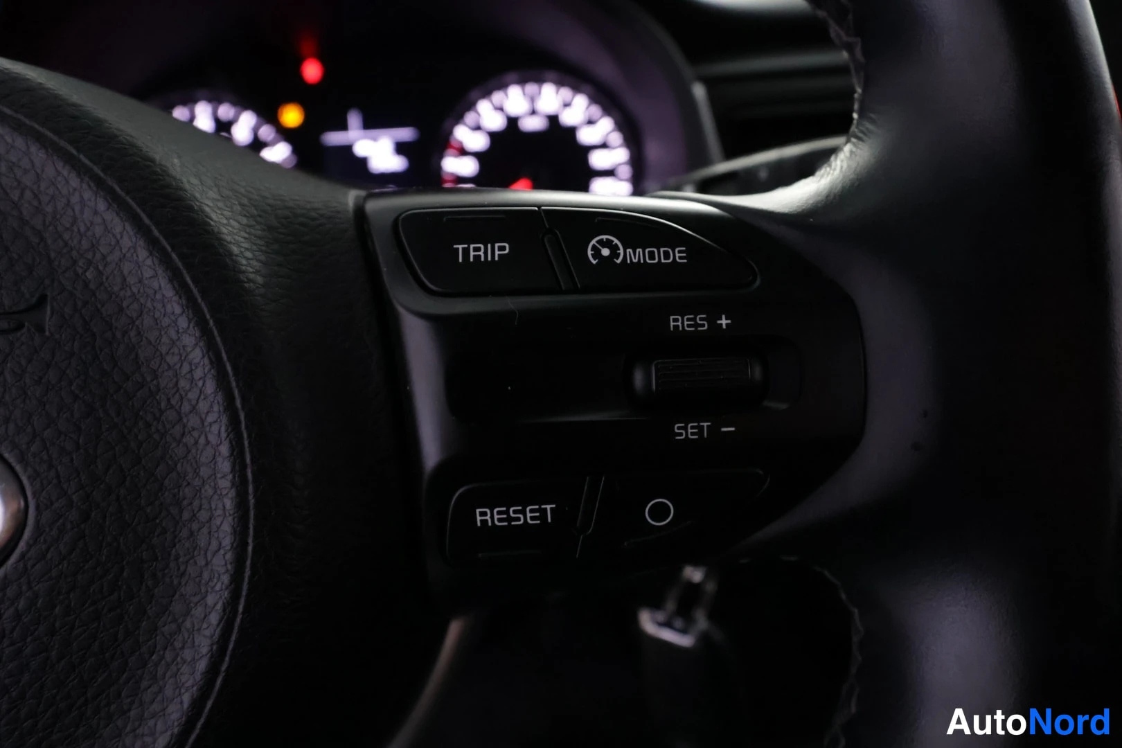 Muu: Ohjauspyörän oikean puolen kytkinten lähikuva: TRIP-, MODE- ja RESET-napit sekä risteisäätimet RES+ ja SET−.