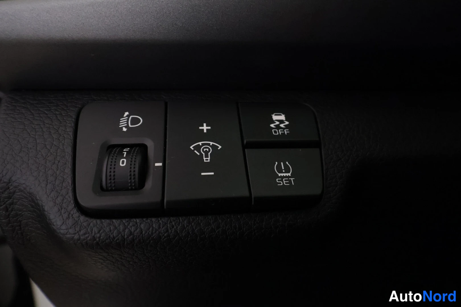 Muu: Sisäkuva: kojelaudan nappiryhmä valonkorkeudensäädöllä, sumuvalo-OFF ja TPMS SET -napeilla.