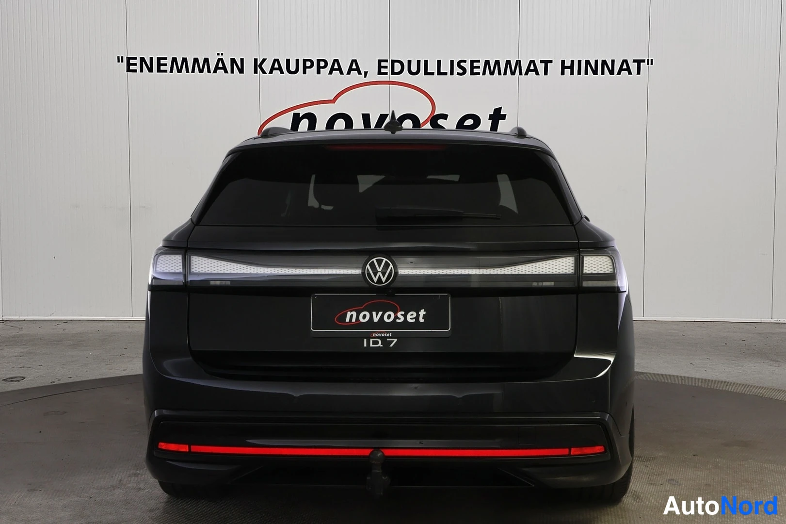 Takaa: Mustan farmariauton perä suoraan takaa kuvattuna. Näkyvät yhtenäinen poikittainen takavalo, VW-merkki, novoset-kyltti rekisterikilven paikalla, ID.7-teksti perä