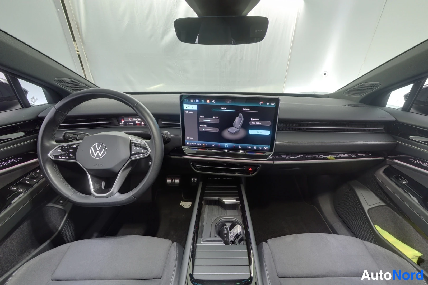 Muu: Ohjaamo takaa eteenpäin kuvattuna: Volkswagenin ohjauspyörä, sen takana digitaalinen mittaristo ja keskellä suuri kosketusnäyttö, jonka valikossa istuinasetukse