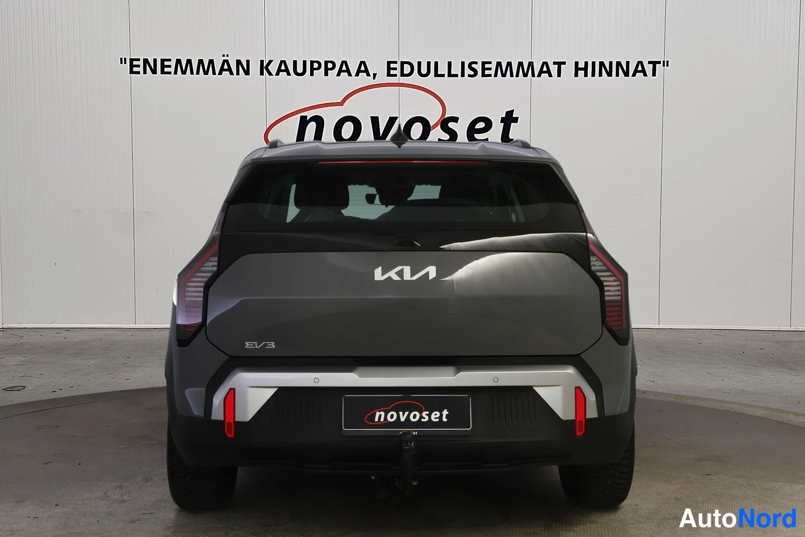 Takaa: Kia EV3 suoraan takaa kuvattuna; tumma takaluukki, Kia- ja EV3-merkit, punaiset heijastimet.