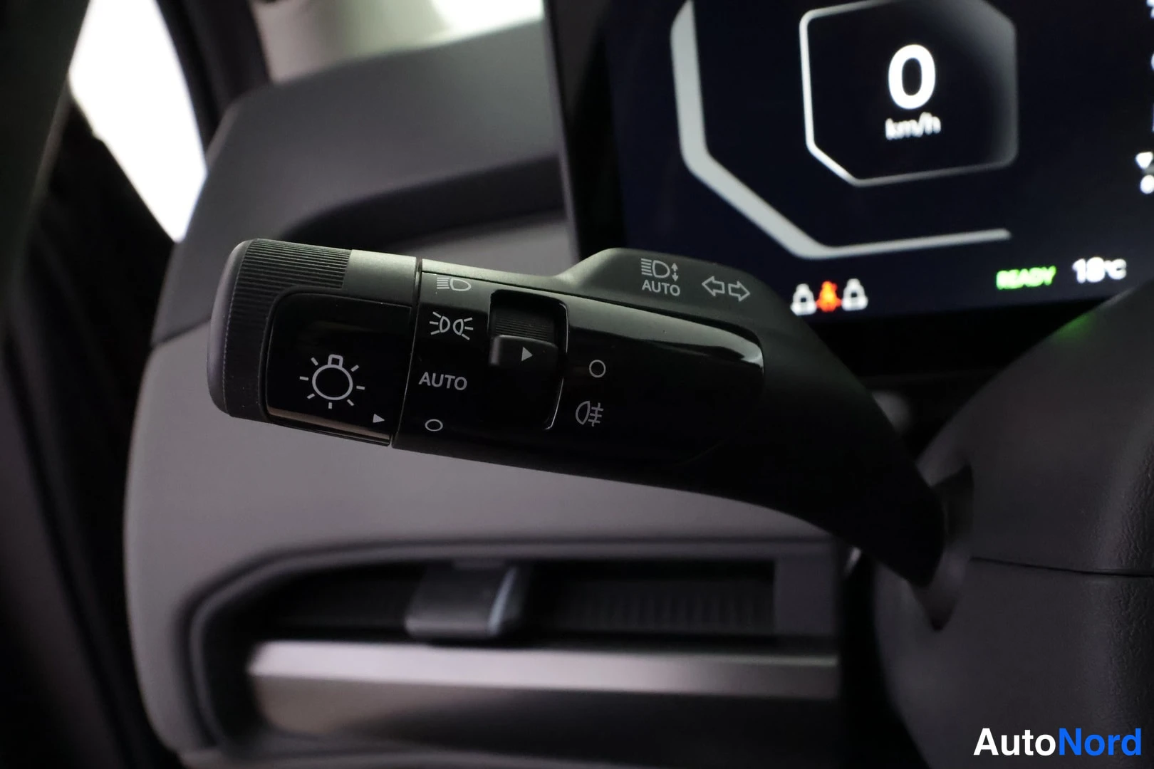 Sivulta: Lähikuva ohjaustangon vivusta: valokytkin AUTO-tekstillä, etu- ja uskovalojen sekä suuntavilkkujen kuvakkeet; taustalla mittaristo, jossa lukee 0 km/h, READY ja