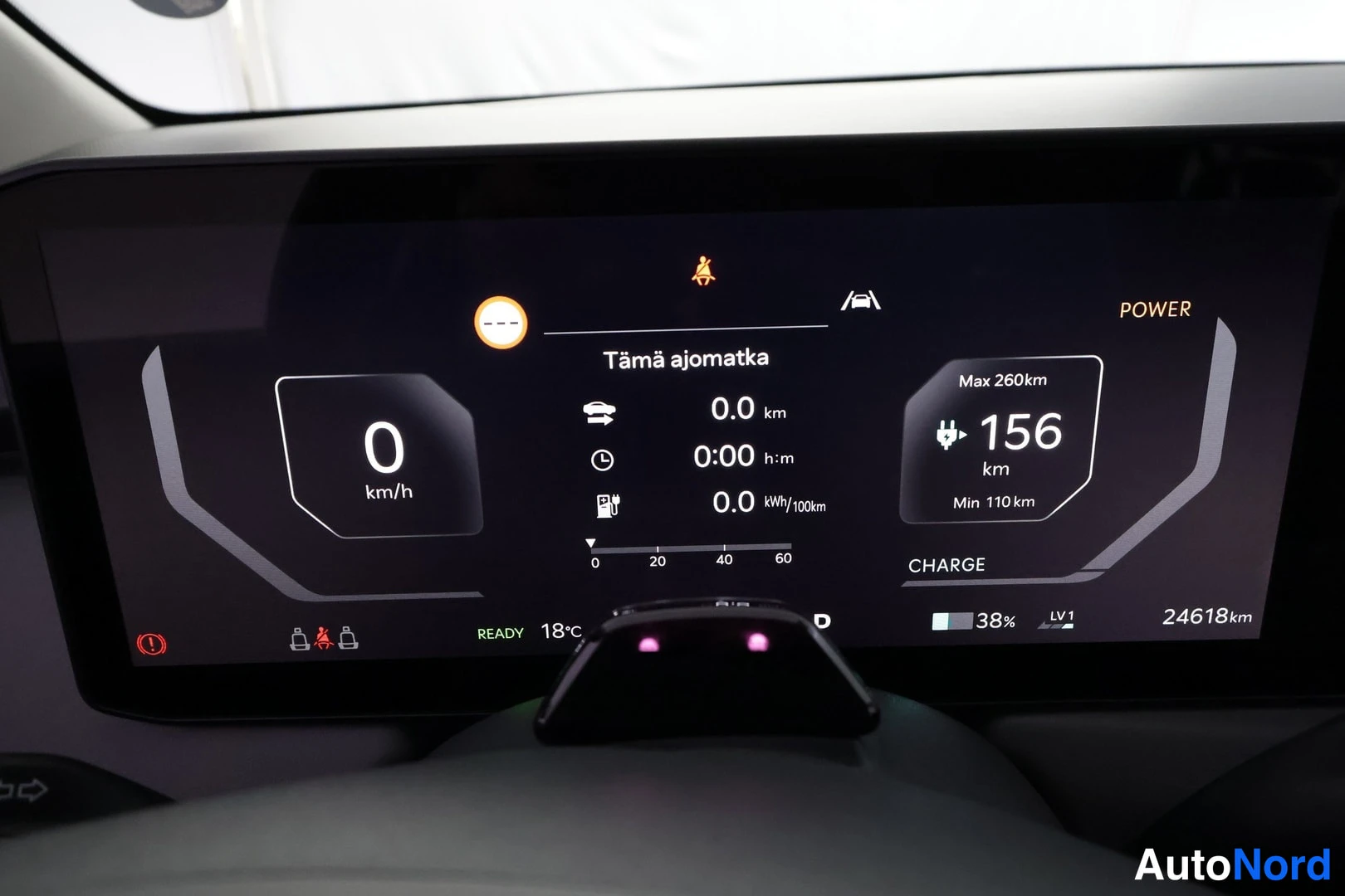Muu: Kojelaudan näyttö: nopeus 0 km/h, tämä ajomatka 0,0 km, CHARGE-tila, jäännösajettavuus 156 km (min 110 km, max 260 km), akku 38 % ja kokonaislukema 24618 km.