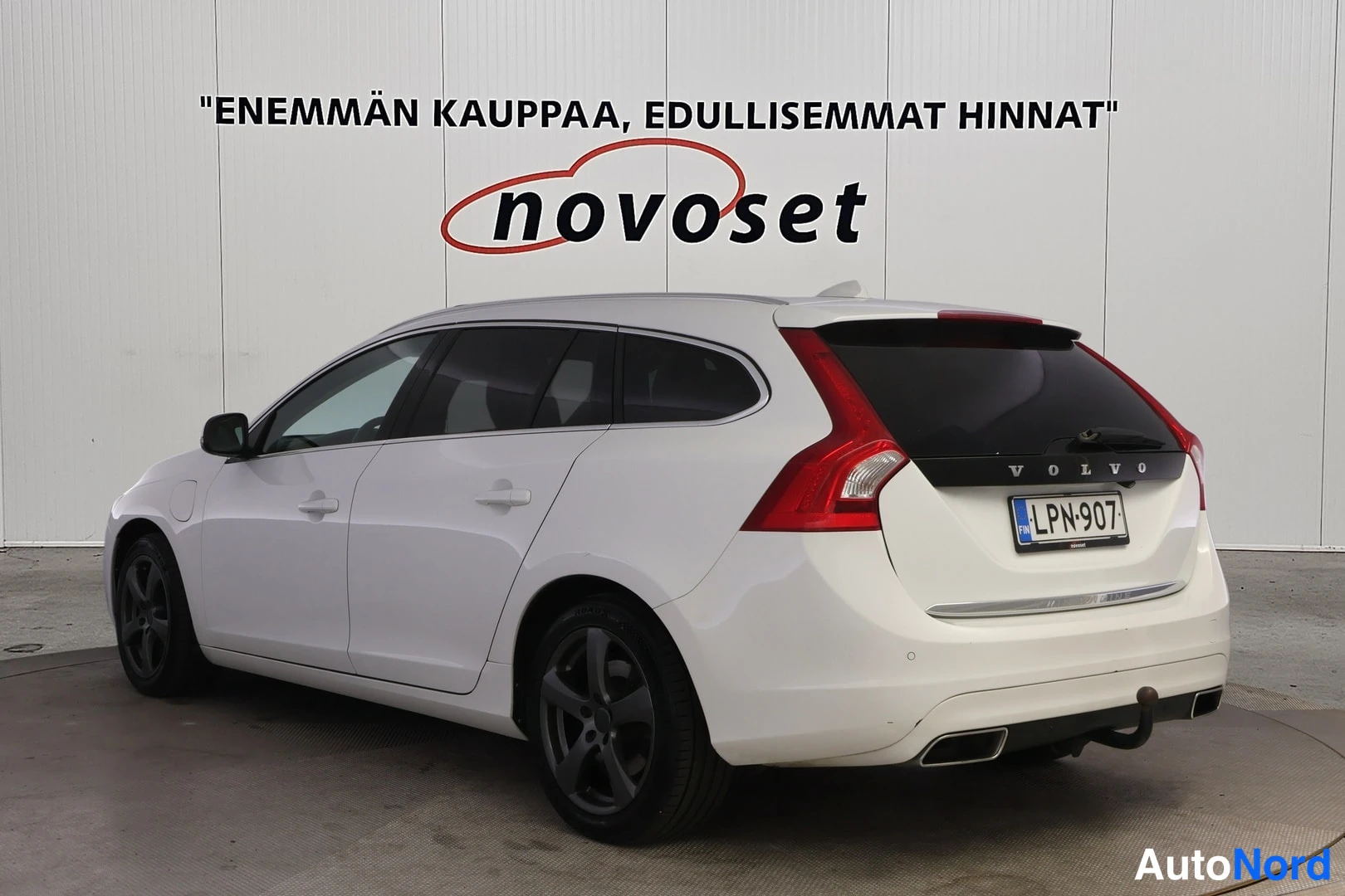 Takaviisto: Valkoisen farmarin takakolmannes vasemmalta; VOLVO-teksti takaluukussa, rekisterikilpi.