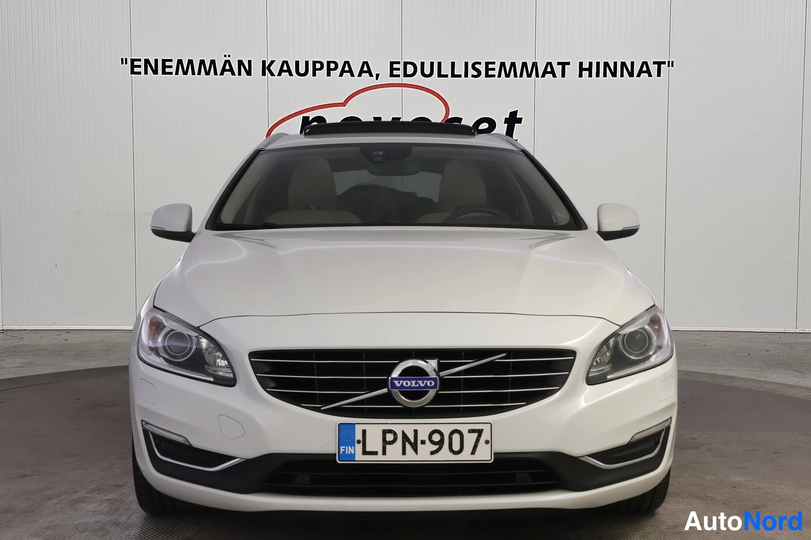 Edestä: Head-on frontal view of a white Volvo V60. Frontal bumper, grille with Volvo logo, and headlights are fully visible.