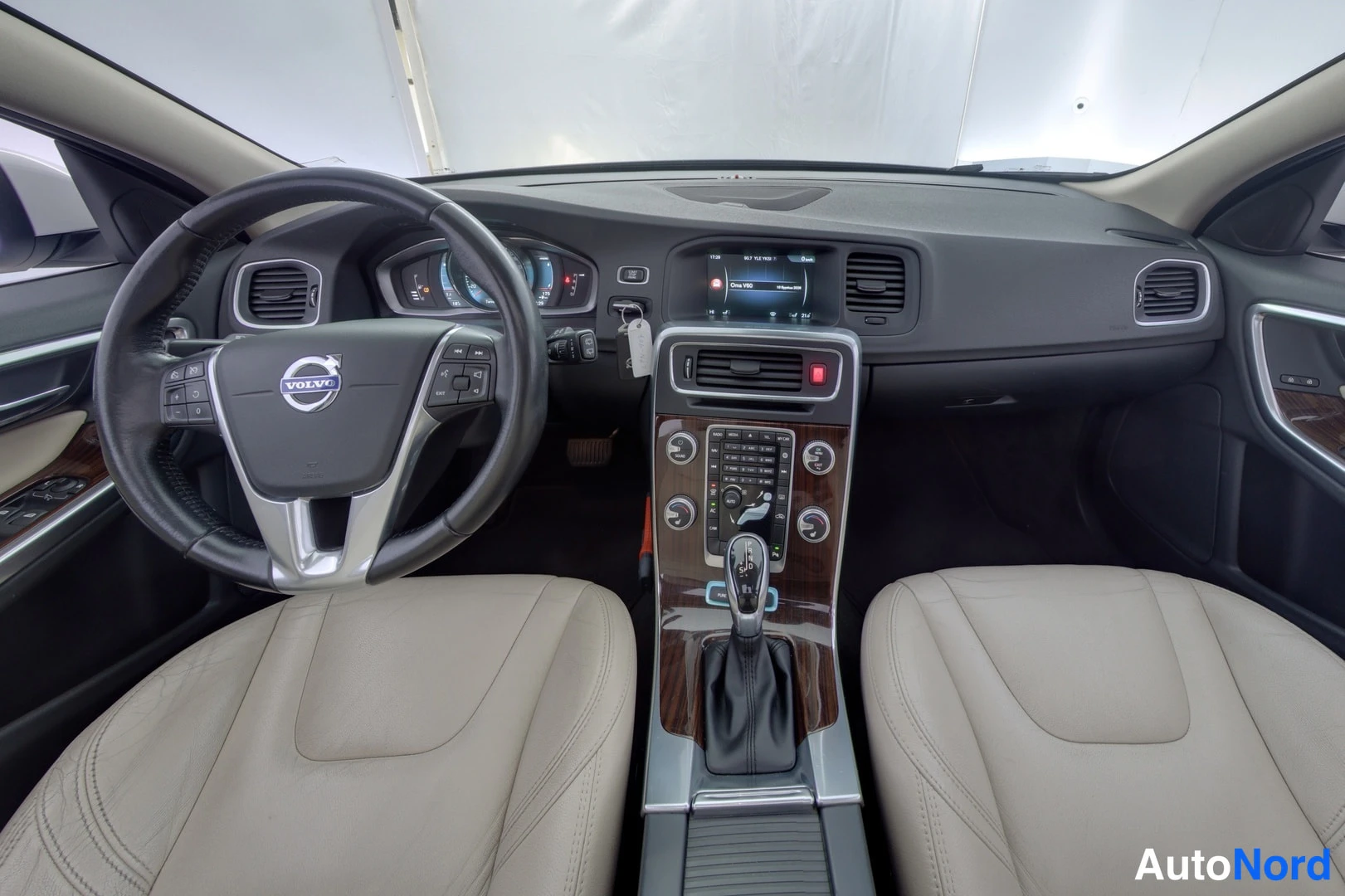 Etuistuimet: Interior wide shot showing two beige leather front seats, dashboard, infotainment screen, and a multifunction steering wheel.